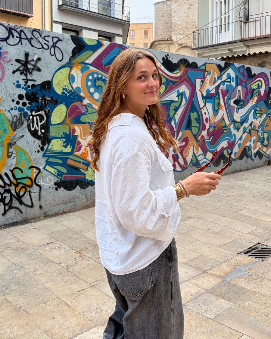 Portrait d’Elaia devant une fresque de rue colorée